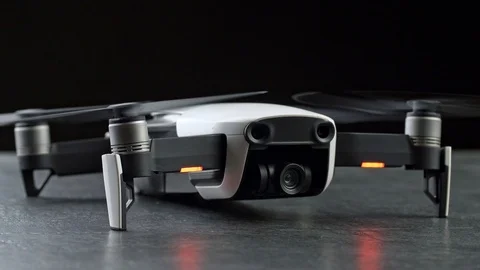 Compact drone quadcopter with digital camera, engines on. Over black background Video stock 103430403