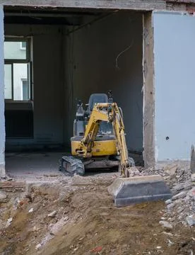 Compact Excavator Inside Building During Interior Demolition Stock Photos