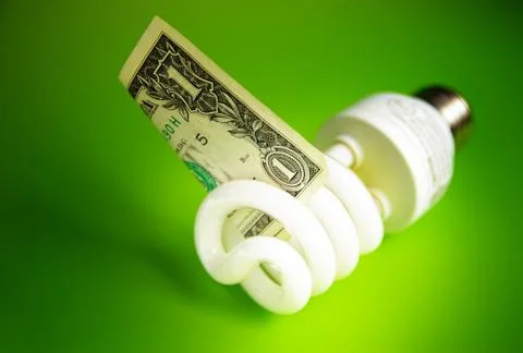 Compact fluorescent light bulb, with a dollar bill Stock Photos