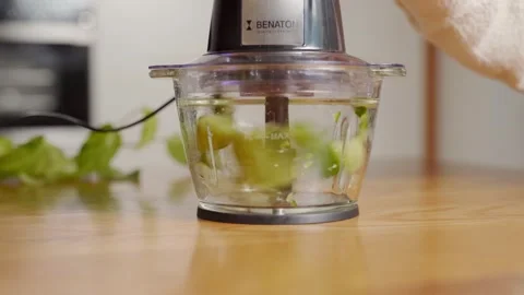 Compact food processor turns cucumber slices into stir. Static closeup Stock Footage 244039268