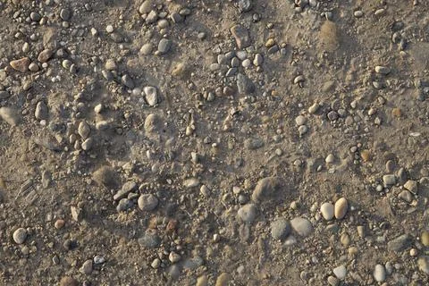 Compact ground made up of sand and stones, light at sunset Stock Photos
