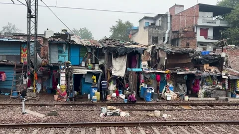 Compact housing cluster and slum area bordering railway tracks in developing Stock Footage 329607938