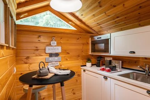 Compact kitchen with small round dining table in wooden house. Village life c Photos