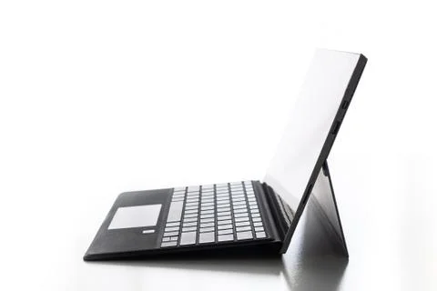 Compact laptop  tablet opened exposed keys pure white background Fotos de archivo