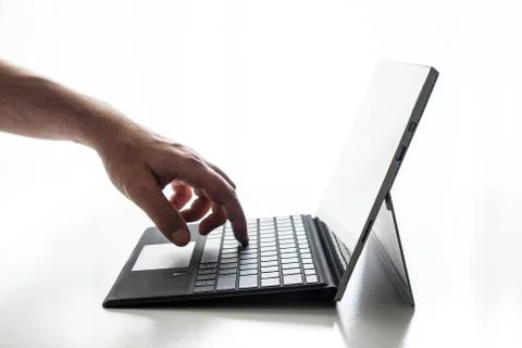 Compact laptop  tablet opened exposed keys pure white background hand Fotos de archivo