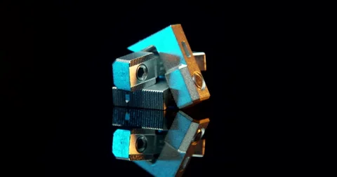 Compact metal connector block spinning with cyan and gold reflections Stock Footage 331436707
