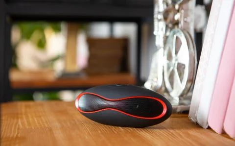 Compact mini Bluetooth speaker in the interior on the shelf in the living room Stock Photos