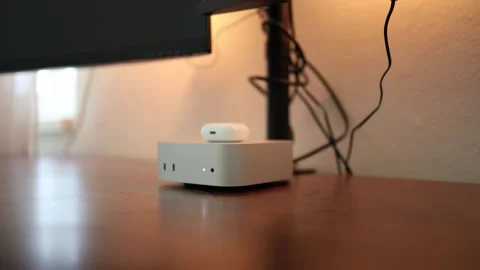 Compact mini computer with system on chip sits beneath a monitor on a home desk Stock Footage 344055599