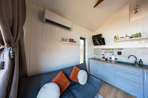 Compact Nordic tiny house interior with slate blue kitchenette Stock Photos
