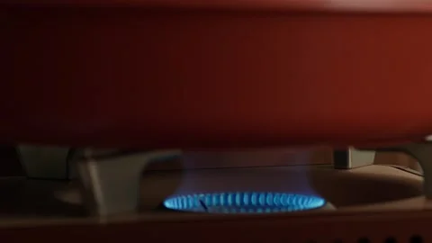 Compact portable gas stove with ignition, blue flame burning on kitchen gas Stock Footage 320022098