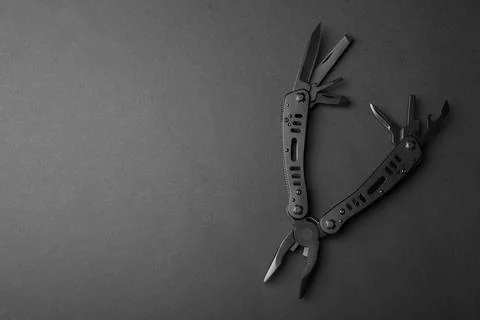 Compact portable multitool on black background, top view. Space for text Stock Photos