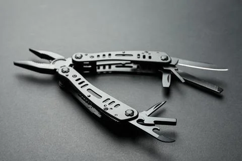 Compact portable multitool on black background, closeup Stock Photos