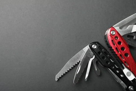 Compact portable multitool on grey background, top view. Space for text Stock Photos