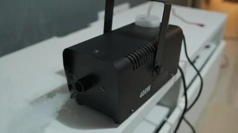 Compact smoke machine releasing theatrical fog indoors, professional stage Stock Footage 334946323