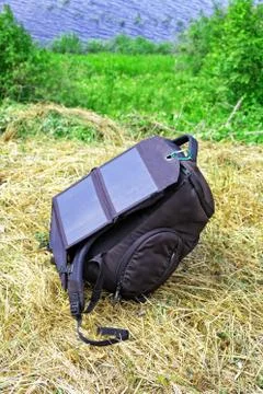 Compact solar panel is attached to the backpack for charging gadgets outdoor Stock Photos