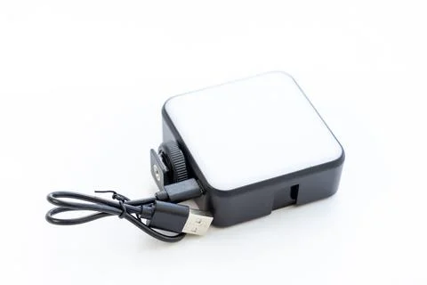 Compact square LED video light with charging cable attached 库存照片