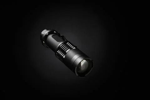 Compact tactical flashlight isolated on black background with focused lens .. Stock Photos