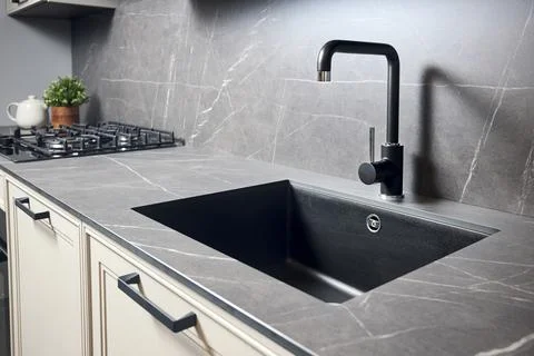 Compact undermount sink. Kitchen sink area with black square matte sink tap in Stock Photos