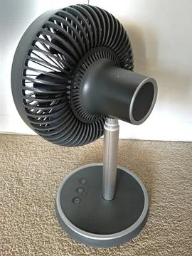 A compact white and black electric fan with spiral grille Stock Photos