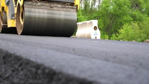 Compactor constructing highway. Steamroller slowly ride. Roadway repair by heavy Stock-Footage 326645773