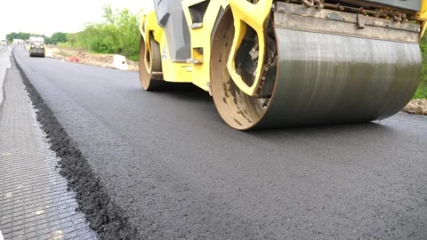 Compactor constructing highway. Steamroller slowly ride. Roadway repair by heavy Видео 335817935