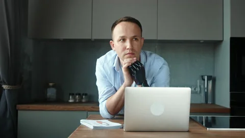 Company manager guy with hand prothesis sits at table Stock Footage 157349826