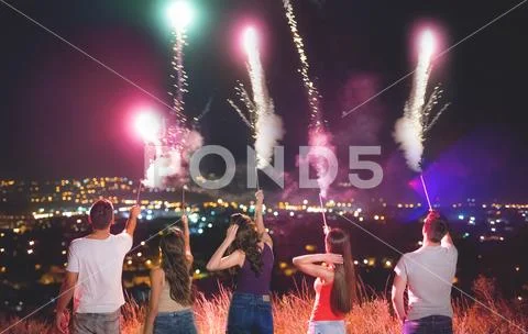 The company of people hold firework sticks. evening night time Stock Photos