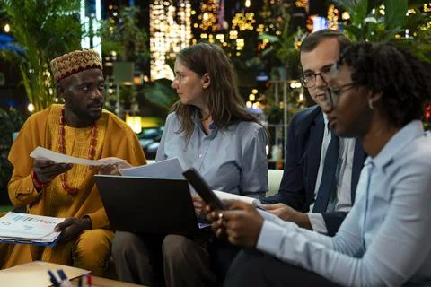 Company representatives compare laptop data and paperwork information Stock Photos
