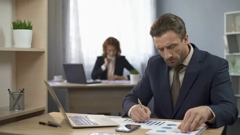 Company worker checking documents with charts, comparing results, data analysis Stock Footage 76164760
