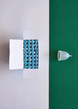 A comparison flat lay of tampons and a more eco-friendly menstrual cup Stock Photos