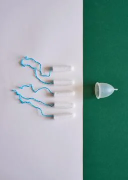 A comparison flat lay of tampons and a more eco-friendly menstrual cup Stock Photos