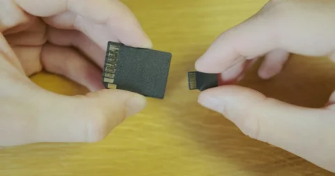 Comparison of micro sd memory card and sd adapter. Hands holding micro sd flash Vídeos de archivo 200835783