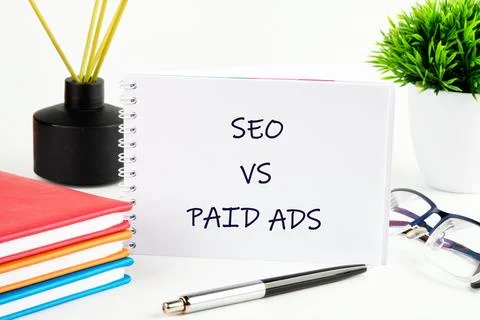 Comparison of search engine optimization and paid advertising strategies writ Fotos de archivo