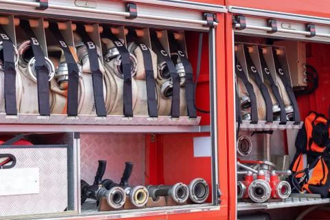 Compartment of rolled up fire hoses on a fire engine. Rescue fire truck equip Stock Photos