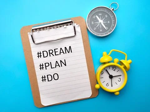 Compass and clock with text hashtag Dream,Plan and Do on blue background. Stock Photos
