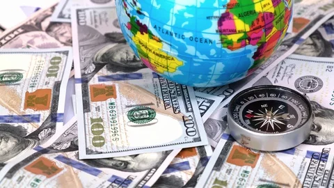 Compass and Globe of Planet Earth on a Background of Many 100 Dollars Banknotes Stock Footage 129419731