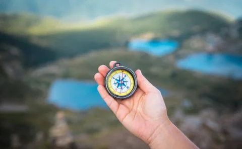 Compass and hand in mountains Foto stock