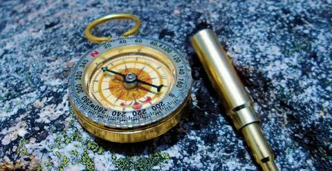 Compass and key ring in the form of a spyglass Stock Photos