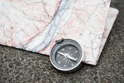 Compass and map on the asphalt Stock Photos