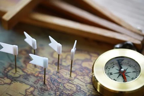 Compass and White Flags on Map Representing Exploration and Travel Planning Stock Photos