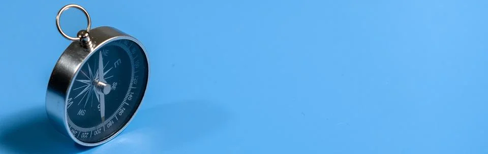 Compass on blue background with copy space. Direction concept. Banner Stock Photos