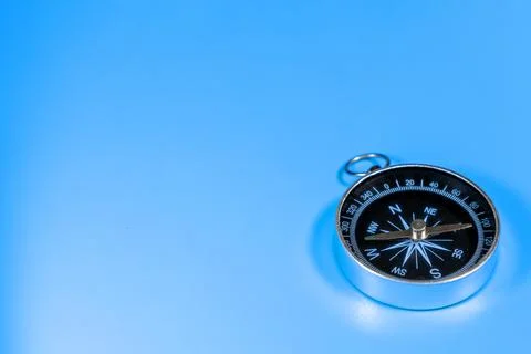 Compass on blue background with copy space. Direction concept Stock Photos