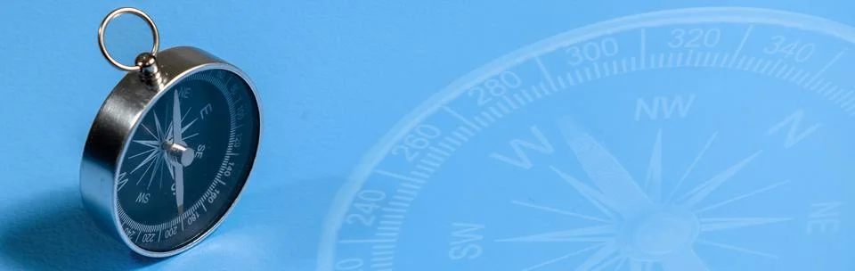 Compass on blue background with copy space. Direction concept. Banner Stock Photos