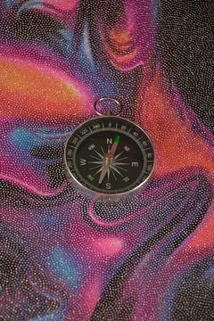 Compass on a bright multi-colored background, close-up Stock Photos