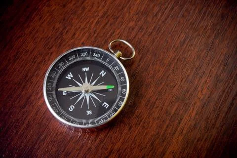 Compass on brown desk Stock Photos