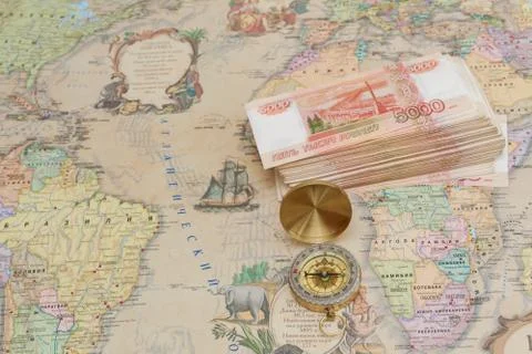 Compass with a bundle of big money are on the map Stock Photos