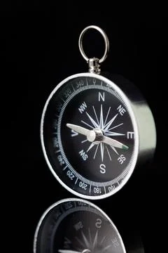 Compass on dark black background using as direction. Vertical image Stock Photos