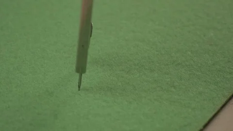 Compass draws a circle on a green background. Tools for drawing. Creating a Stock Footage 103592120