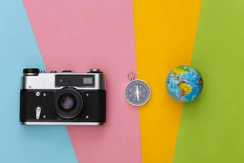 Compass, globe and camera on colored background. Travel, adventure flat lay.  Stock Photos
