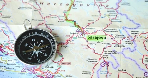 A compass going crazy while lying on a roadmap showing the Olympic city Sarajevo Stock Footage 55328708